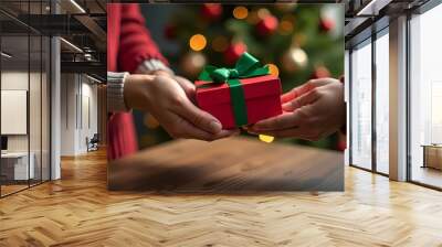 Woman`s hands gives each other a gift. Festive background. Red box with greenn ribbon.  Banner, Poster, greeting card. Wall mural